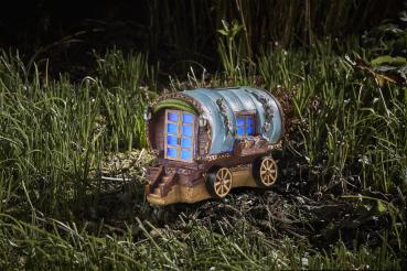 Preview: Ein kleines Feenhaus in Form eines Campingwagens beleuchtet im Garten